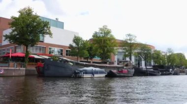 Kanallar boyunca bir tekneye binip güneşli bir günde Amsterdam 'da evler ve binaların yanında dolaşmak.. 
