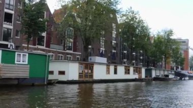 Kanallar boyunca bir tekneye binip güneşli bir günde Amsterdam 'da evler ve binaların yanında dolaşmak.. 
