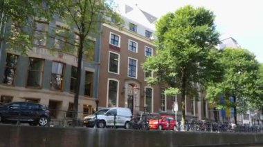 Kanallar boyunca bir tekneye binip güneşli bir günde Amsterdam 'da evler ve binaların yanında dolaşmak.. 