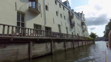 Kanallar boyunca bir tekneye binip güneşli bir günde Amsterdam 'da evler ve binaların yanında dolaşmak.. 