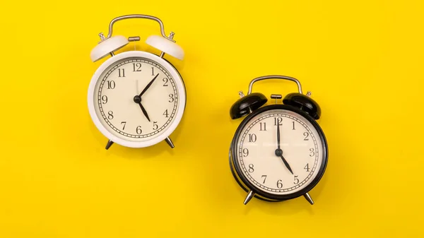 時計のコンセプトのコピースペース 時間の重要性についての時間概念 黄色の背景に黒と白の目覚まし時計の選択的な焦点 — ストック写真