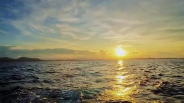 Hareket halindeki bir teknede gün batımında bir video.