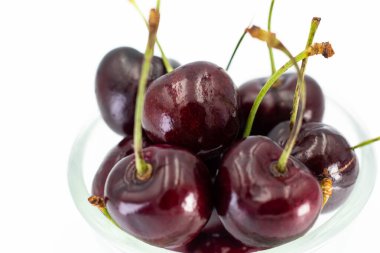 Olgun vişne grubu beyaz arkaplanda izole edilmiş cam içinde