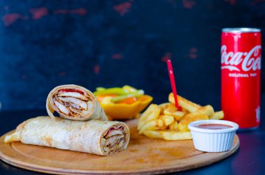 Doner kebab in lavash bread. Close-up delicious chicken doner burrito on black background. Potato chips. selective focus
