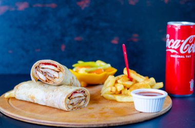 Doner kebab in lavash bread. Close-up delicious chicken doner burrito on black background. Potato chips. selective focus