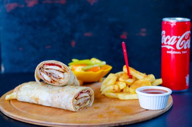 Doner kebab in lavash bread. Close-up delicious chicken doner burrito on black background. Potato chips. selective focus