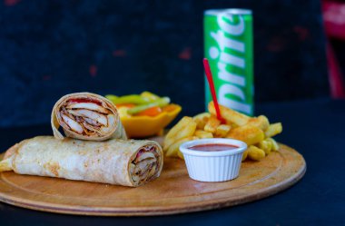 Doner kebab in lavash bread. Close-up delicious chicken doner burrito on black background. Potato chips. selective focus