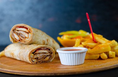 Doner wrap kebab on wooden presentation board. Lavash is doner in bread. Traditional Turkish cuisine.