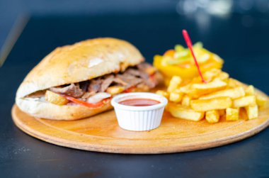 Chicken doner kebab in bread. Doner kebab in bread on wooden board on black background.