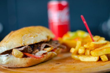 Chicken doner kebab in bread. Doner kebab in bread on wooden board on black background.