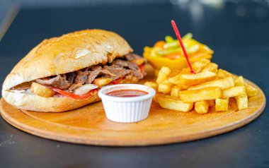 Chicken doner kebab in bread. Doner kebab in bread on wooden board on black background.