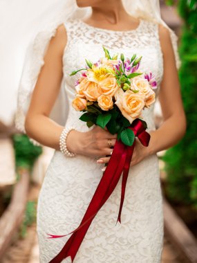 Gelin düğün buketi tutuyor.