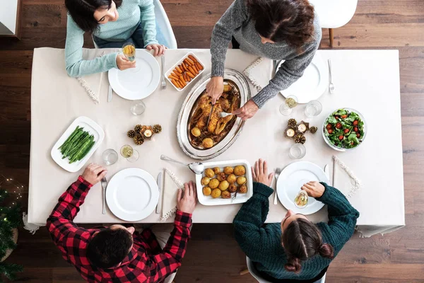 Pohled na vánoční rodinnou večeři. Starší běloška krájí vánoční pečené kuře. Rodinné shromažďování. — Stock fotografie