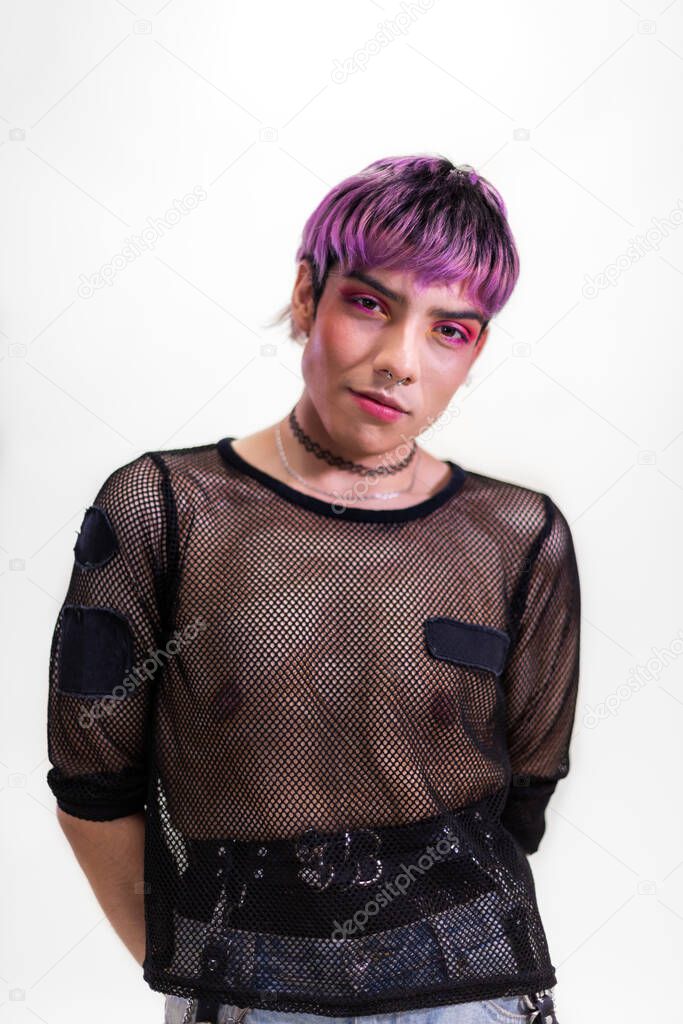 Portrait of young man with purple hair wearing hot pink eye makeup and black mesh t-shirt. Vertical image.
