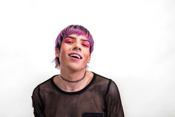 Mladý muž s horkým růžovým okem make-up a fialové vlasy s chladným postojem dívá do kamery. Kopírovat prostor. — Stock fotografie