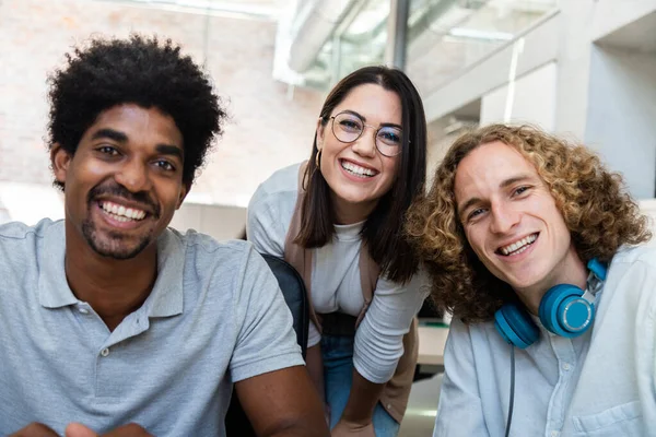 Glimlachend jong multiraciaal team van collega 's kijkend naar camera in het kantoor. — Stockfoto