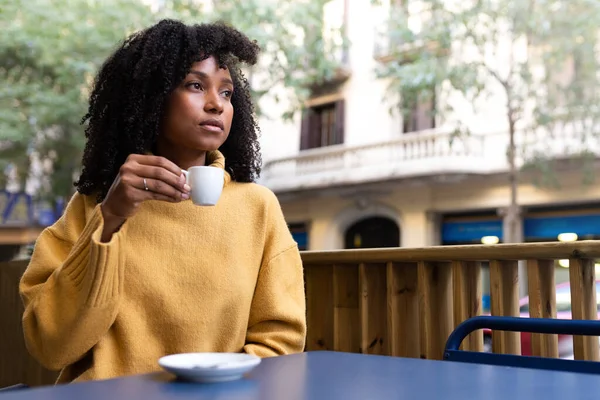 Ung afroamerikansk kvinna håller kaffekopp i utomhus café terrass. Kopiera utrymme. — Stockfoto