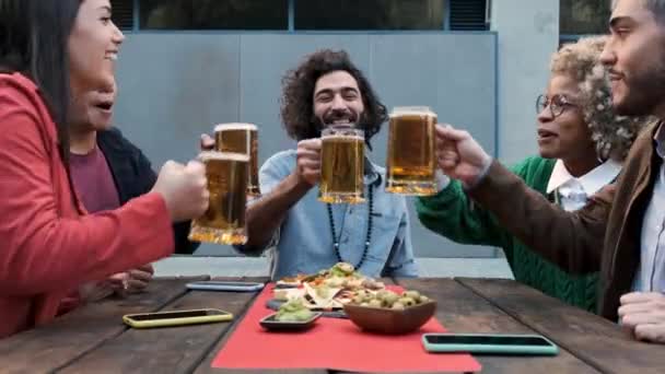 Díky. Multiraciální, šťastní přátelé toust s pivem a smát se v baru venku. — Stock video