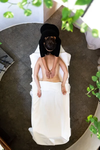 Vista superior de la mujer recibiendo un masaje en un espacio tranquilo y sereno. — Foto de Stock