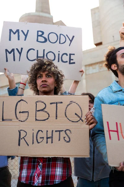 Protesto için elinde LGBTQ karton tabela tutan Afrikalı Amerikalı kadın. Dikey resim.