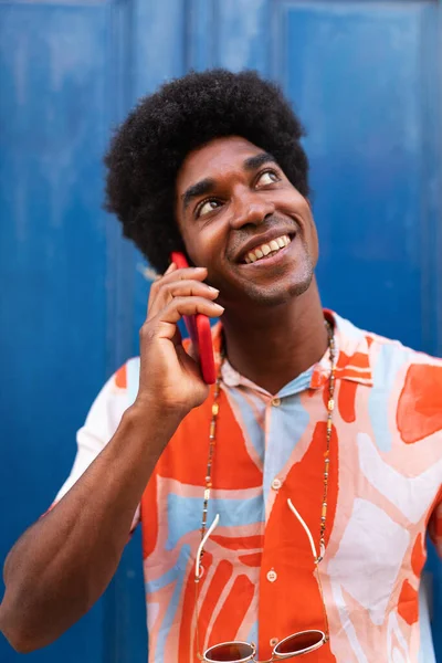 幸せな黒人男性の垂直肖像電話で話している。アフリカ系アメリカ人の男が路上で携帯電話を使って. — ストック写真