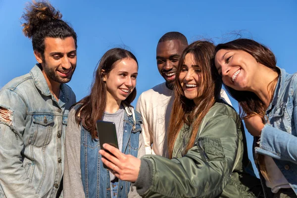 Multiraciale vrienden die mobiele telefoon gebruiken om naar de app voor sociale media te kijken. selfie nemen. Veel plezier.. — Stockfoto