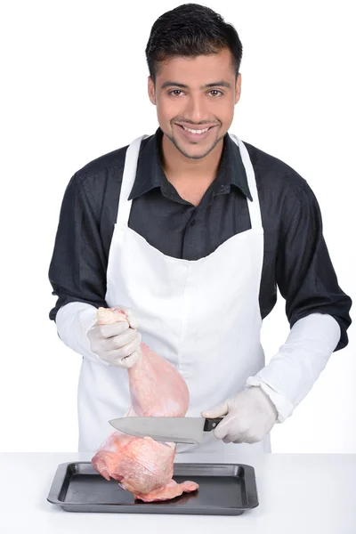年轻英俊的男人抱着土耳其腿 专业的屠夫围裙微笑和烹饪火鸡的腿 — 图库照片