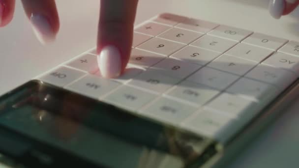 Detailní záběr ženských prstů mačkajících tlačítka bílé kalkulačky. — Stock video