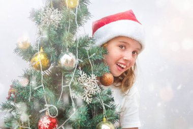Meşgul bir Noel ağacının arkasından gözetleyen genç kız.