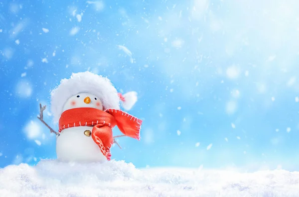 Kardan adam Noel Baba şapkasıyla kar yığınında tatil arka planında