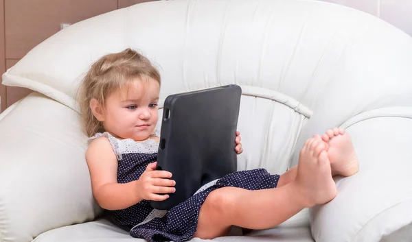 Kind Meisje Ligt Stoel Speelt Tablet — Stockfoto