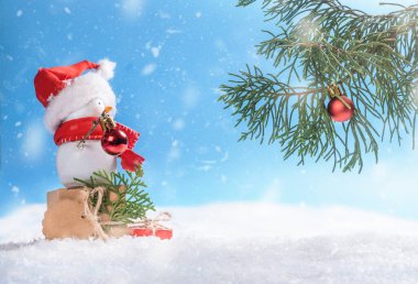 Mutlu kardan adam Noel ağacını Noel süsüyle süslüyor.