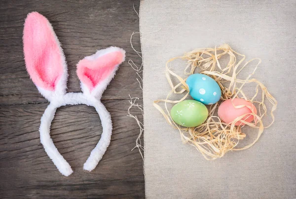 Tavşan kulakları ve tahta arka planda Paskalya yumurtaları.