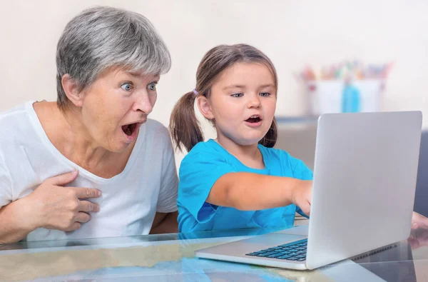Een Kind Een Senior Blik Een Laptop Met Verrukking Verrassing — Stockfoto