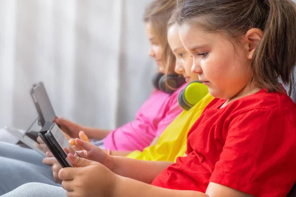 Niños Niñas Sentadas Juntas Sofá Mirar Cuidadosamente Las Tabletas —  Fotos de Stock