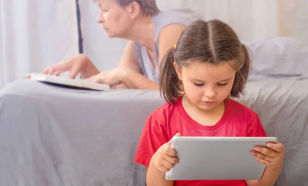 Het Kind Zit Grond Met Een Tablet Grootmoeder Ligt Het — Stockfoto