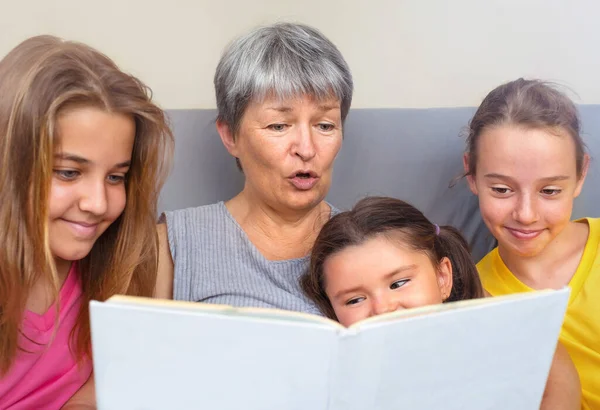 Grandmother Reads Book Stories Her Granddaughters Sitting Together Couch — Stock Photo, Image