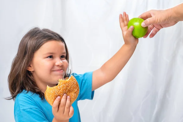 Çocuk Kız Bir Büyüğün Elinden Elma Almayı Reddediyor Hamburger Seçiyor — Stok fotoğraf