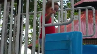 Çocuk parktaki çocuk çocuk kaydırağından iniyor.