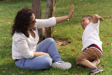 Latin anne ve çocuk güzel bir yaz öğleden sonrasında parkta oynuyorlar. Yaşam biçimi.