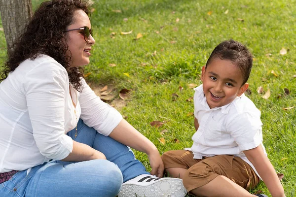Latin anne ve çocuk güzel bir yaz öğleden sonrasında parkta oynuyorlar. Yaşam biçimi.