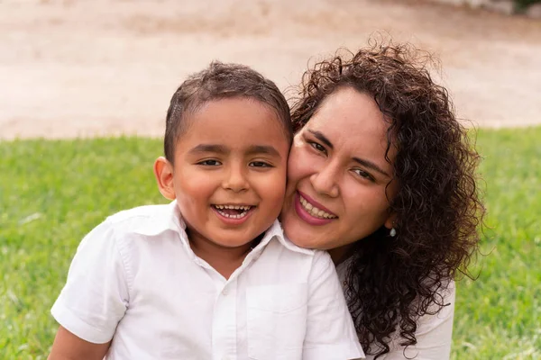 Portrait of Latin mother and child happy to be together in the park on a beautiful summer afternoon. Lifestyle.