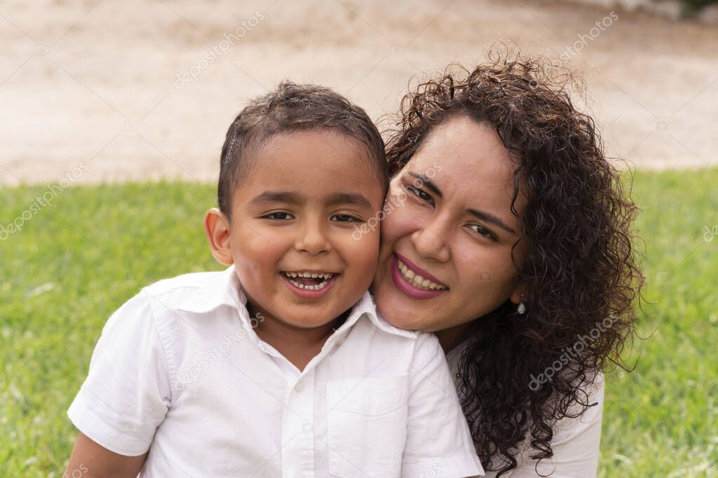 Portrait of Latin mother and child happy to be together in the park on a beautiful summer afternoon. Lifestyle.