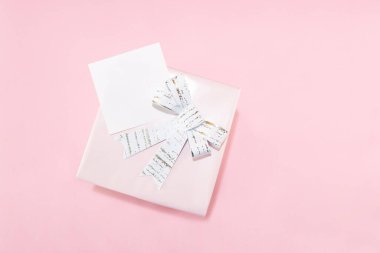 Genel çekim, hediye ile pembe arkaplan kompozisyonu ve Anneler Günü veya Kadınlar Günü için beyaz kurdele. Hediyenin üzerinde yazı için beyaz etiket.