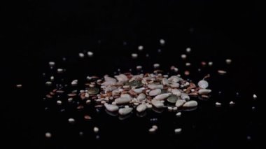 Yatay video, fıskiyeli susam tohumları, kahverengi keten, haşhaş, kabak çekirdekleri ve fiber ve omega 3 içeren ayçiçeği tohumlarının yakın çekimi..