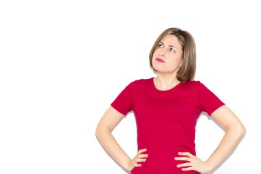 Üzgün genç bir kadının yatay görüntüsü. Beyaz arka planda izole edilmiş kalçalara bakıyor. Kısa saç kesimi ve günlük fuşya tişörtü..