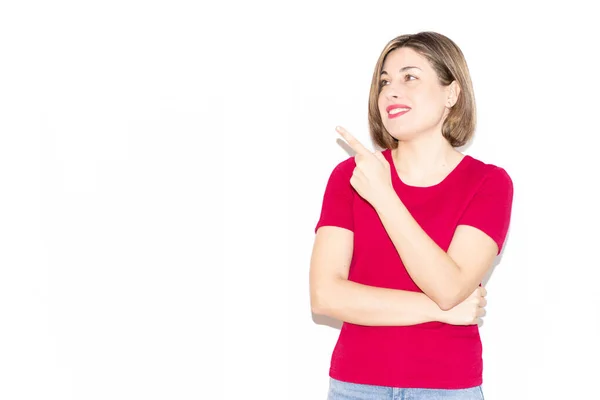 Gündelik pembe elbiseli, sevimli bir genç kadının yatay fotoğrafı arka plandaki boş boşluğu işaret ediyor..