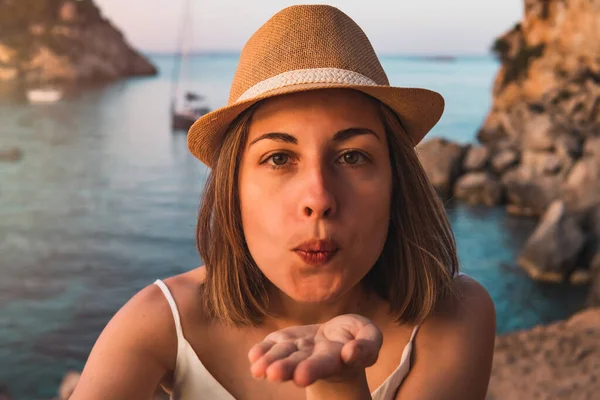 Portre, tatilde olan genç bir kadın, günbatımında Portal Vells Koyu 'nda kameraya çekiliyor, Palma de Mallorca adası, İspanya.