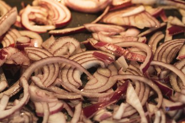 Kızarmış kırmızı soğan dilimleri pişiriyorum..