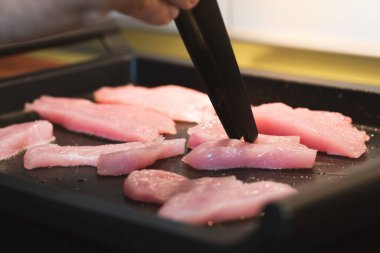 Adam tavada hindi fileto pişiriyor..